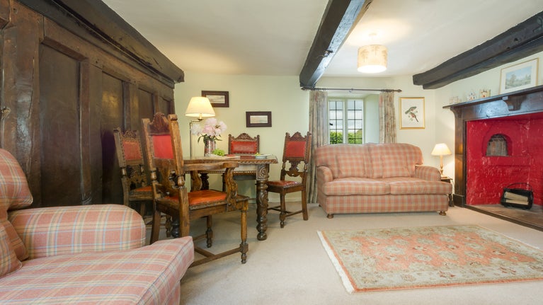 The sitting and dining room with original inglenook at Mattress Cottage, Devon